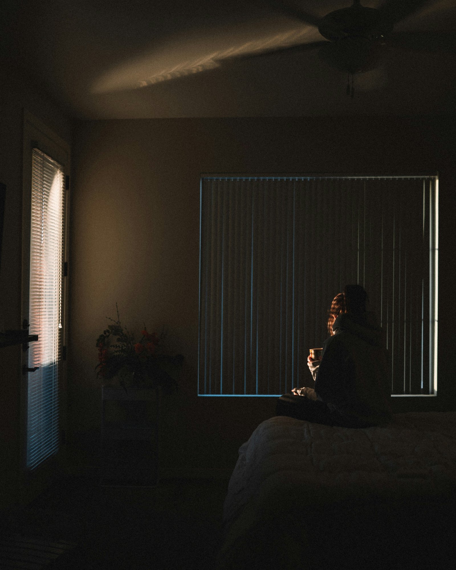 Figura solitária num quarto com luz entrando